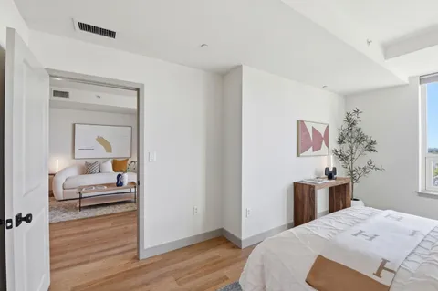 a bedroom with a bed and wooden floor