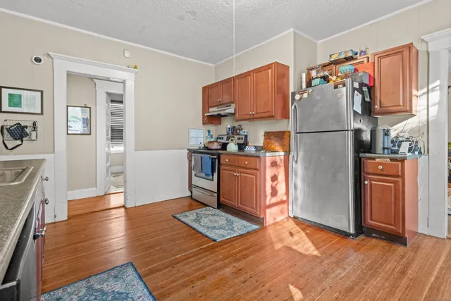 a kitchen with stainless steel appliances granite countertop a refrigerator a stove and a sink