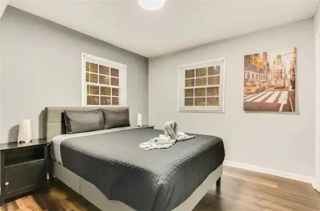 a bedroom with a bed and a painting on the wall