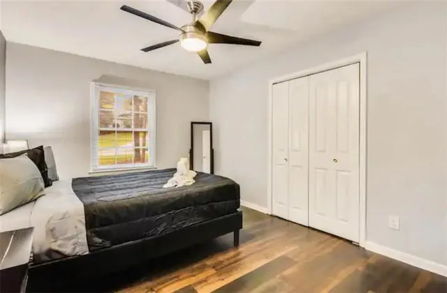a bedroom with a bed and wooden floor