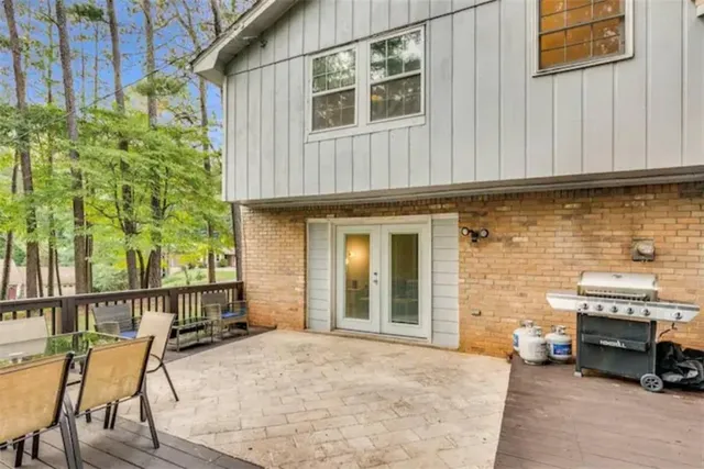 a view of a yard in front of a house with plants and large tree