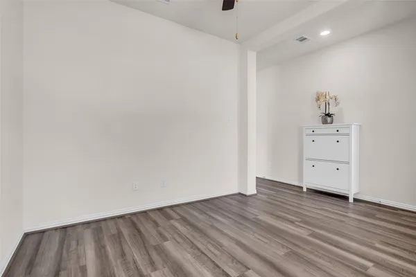 a view of an empty room with wooden floor