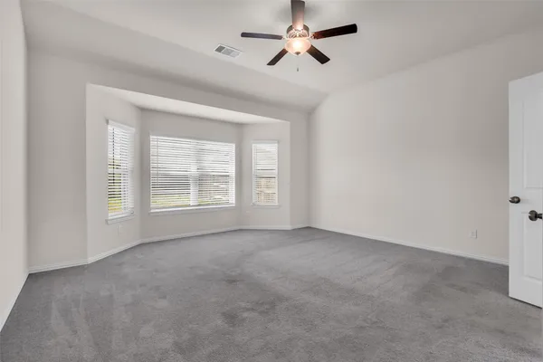 a view of a room with a ceiling fan and window