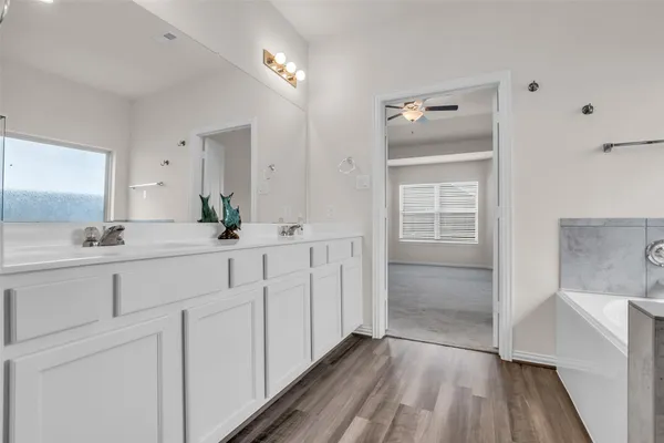 a bathroom with a double vanity sink a mirror and a shower