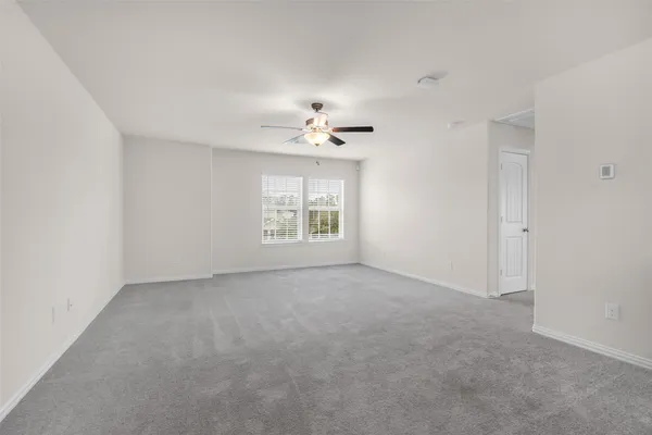 an empty room with a window and a ceiling fan