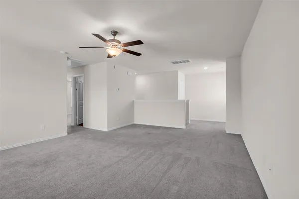 an empty room with closet and a ceiling fan