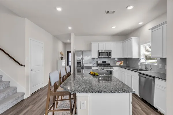 a kitchen with a sink a counter space appliances and cabinets