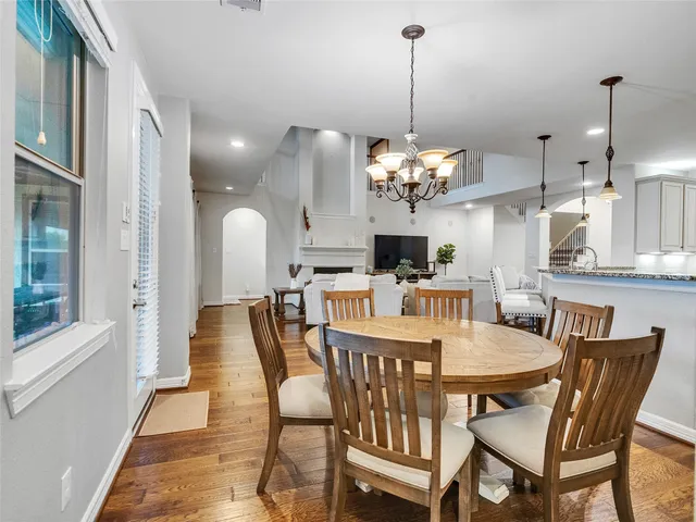 a dining room filled chandelier and wooden floor