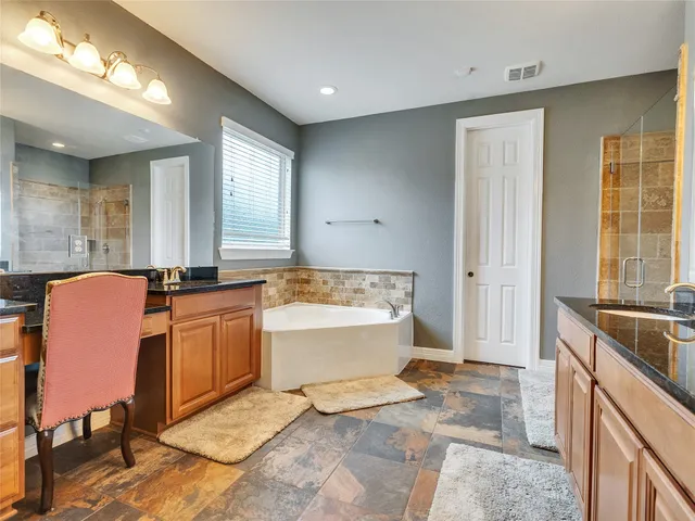 a spacious bathroom with a tub sink and mirror