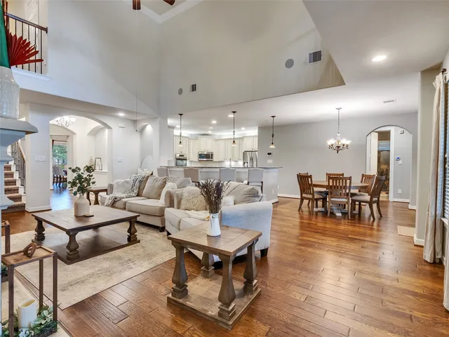 a living room with furniture kitchen view and a wooden floor