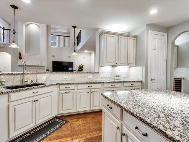 a kitchen with granite countertop a sink and white cabinets