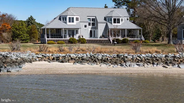 an aerial view of a house with swimming pool and lake view