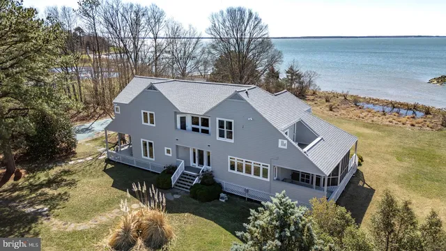 a front view of a house with a yard covered in snow