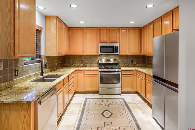 a kitchen with a refrigerator a sink and wooden cabinets