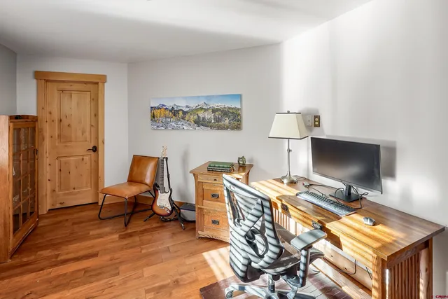 a view of a workspace with furniture and a window
