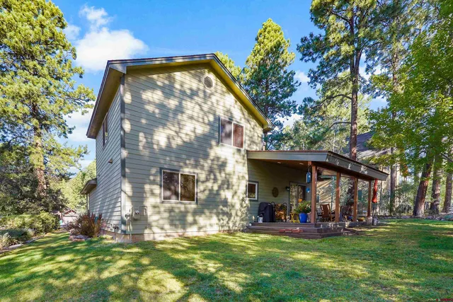 a view of a house with a yard and sitting area