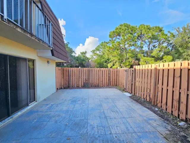 a view of a backyard with wooden fence