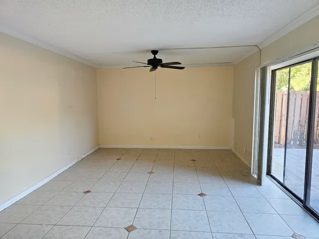 an empty room with a ceiling fan and carpet