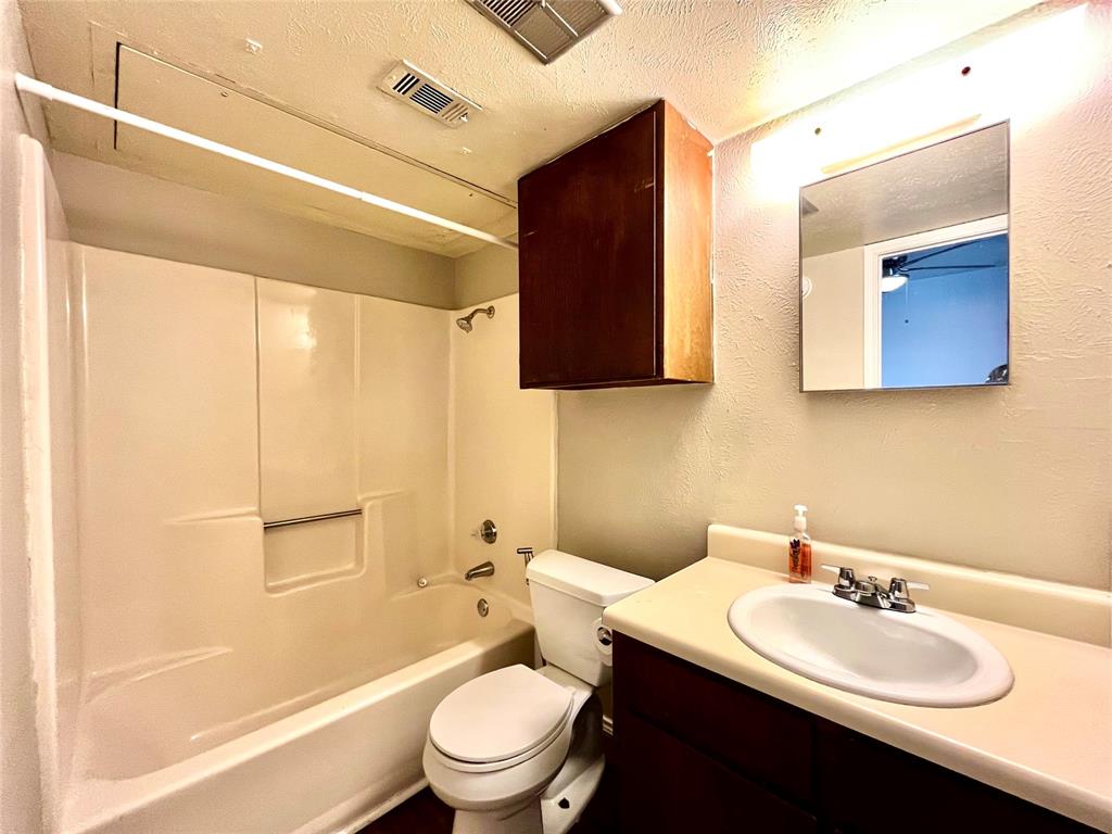 2526 West Prairie Street, Unit 204 Denton, TX 76201 - Photo 6 of 8 a bathroom with a sink a toilet and shower