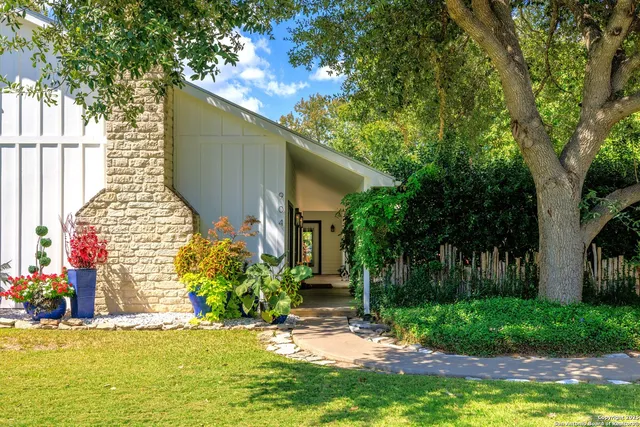 a view of a house with backyard and a tree