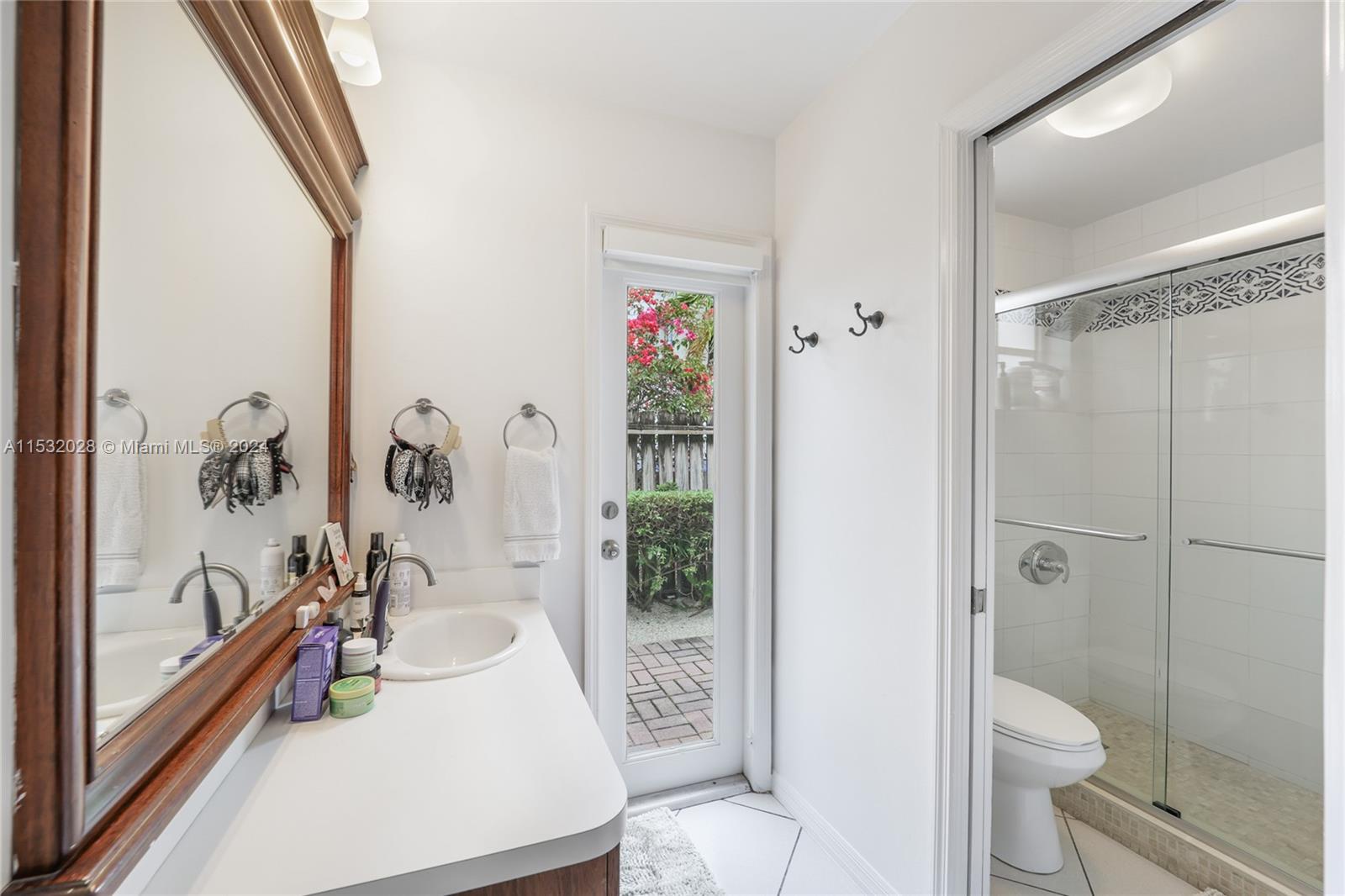 255 Ridgewood Road Key Biscayne, FL 33149 - Photo 11 of 18 a bathroom with a bathtub shower sink mirror and toilet