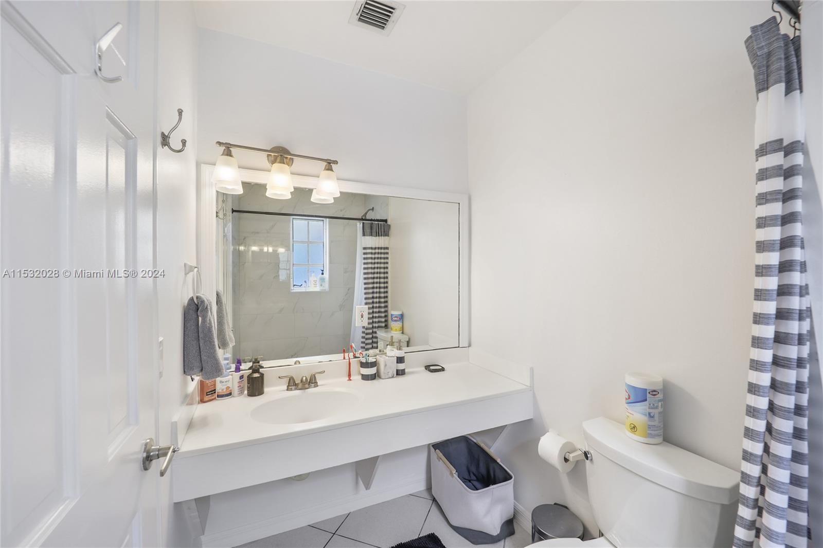 255 Ridgewood Road Key Biscayne, FL 33149 - Photo 16 of 18 a bathroom with a sink vanity mirror and toilet