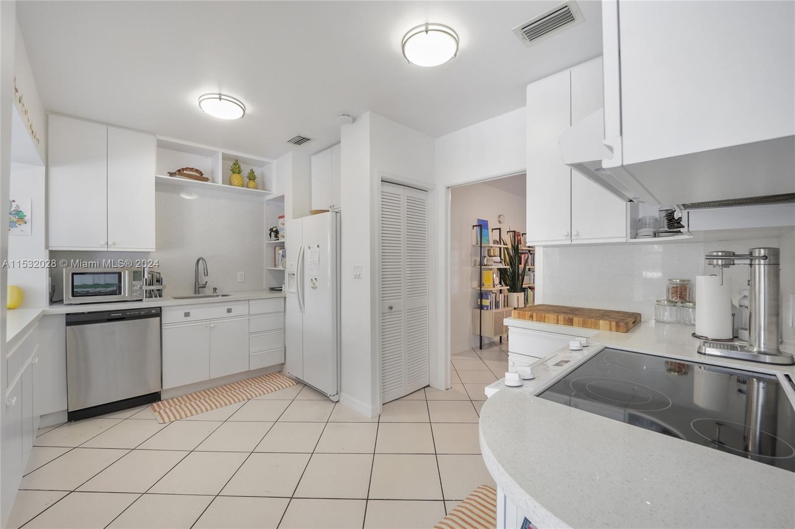 255 Ridgewood Road Key Biscayne, FL 33149 - Photo 8 of 18 a kitchen with a sink cabinets and stainless steel appliances