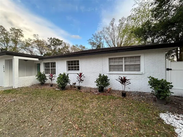 a front view of house with yard and trees around