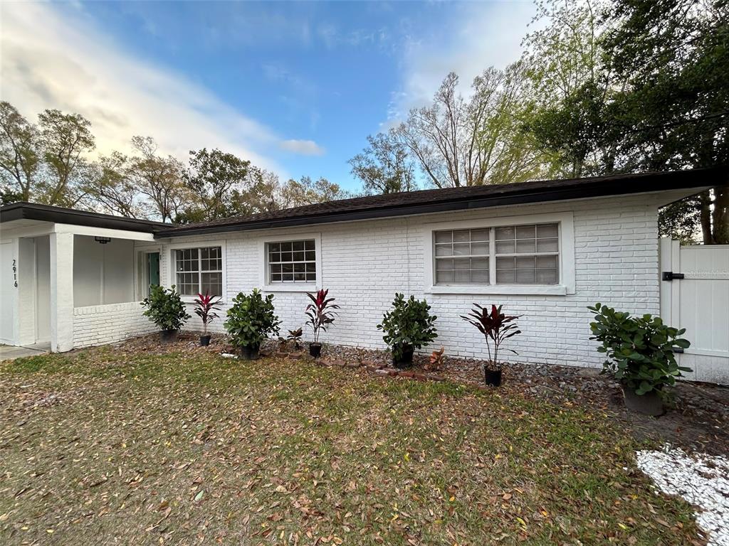 a front view of house with yard and trees around