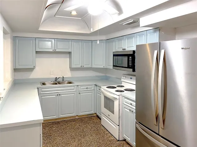 a kitchen with cabinets stainless steel appliances and wooden floor
