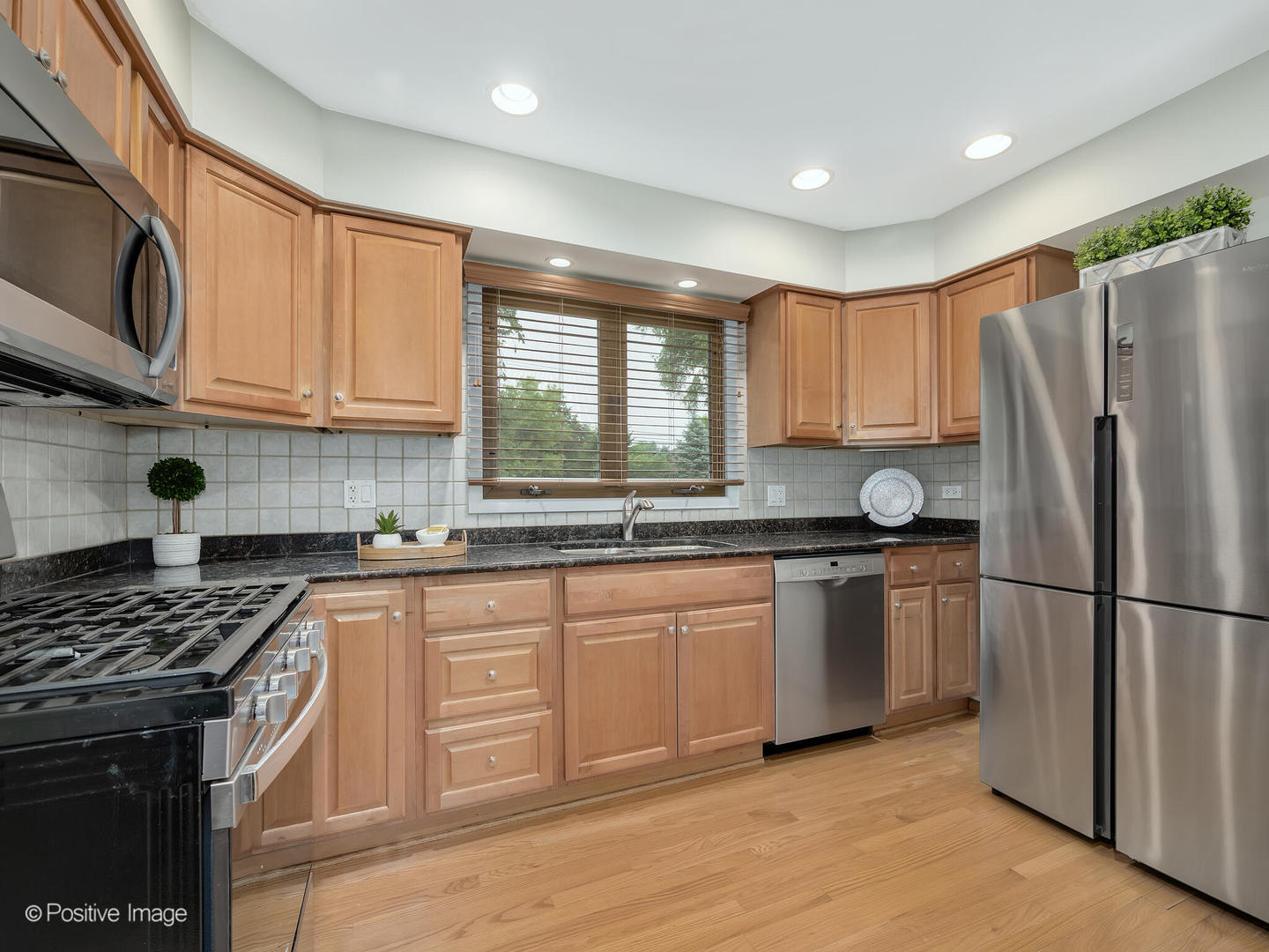 335 Oldfield Road Darien, IL 60561 - Photo 11 of 33 a kitchen with granite countertop a sink stainless steel appliances and cabinets