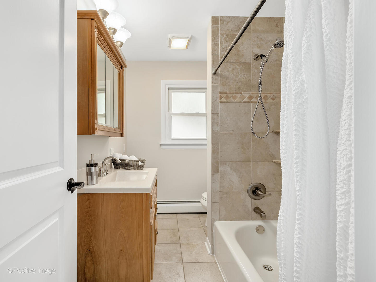 335 Oldfield Road Darien, IL 60561 - Photo 17 of 33 a bathroom with a sink a window and tub
