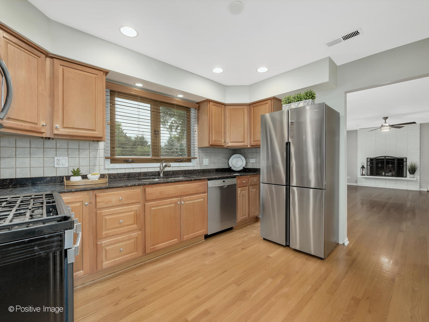 335 Oldfield Road Darien, IL 60561 - Photo 9 of 33 a kitchen with a refrigerator a stove a sink cabinets and wooden floor
