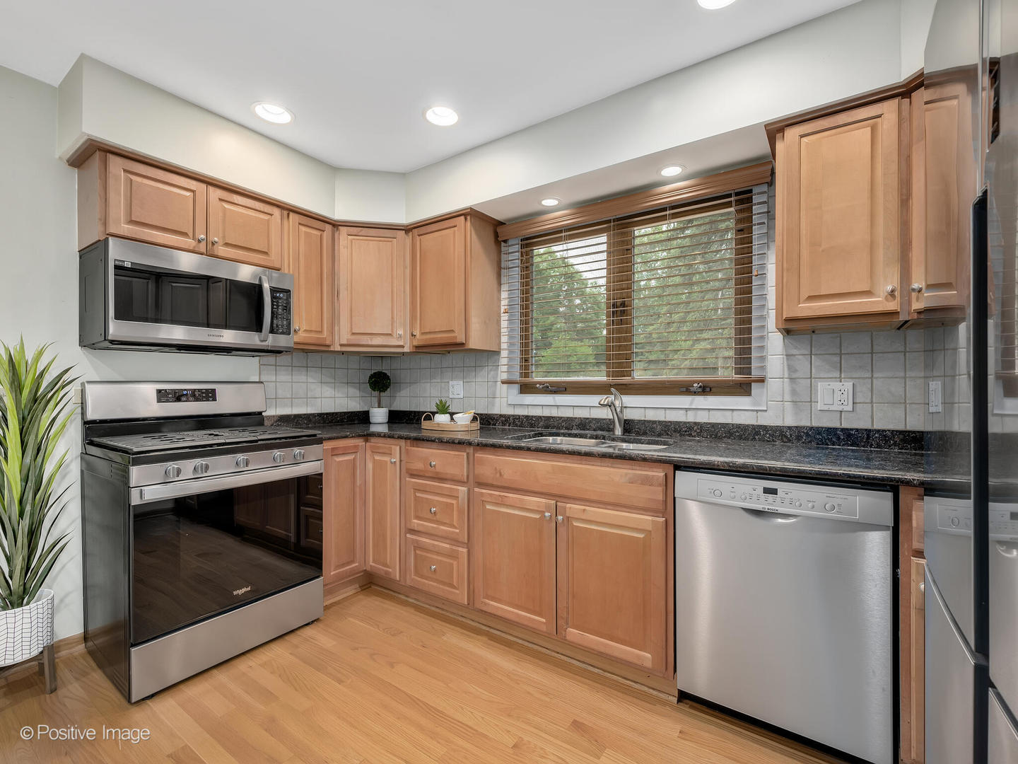 335 Oldfield Road Darien, IL 60561 - Photo 10 of 33 a kitchen with stainless steel appliances granite countertop a stove a sink and a microwave