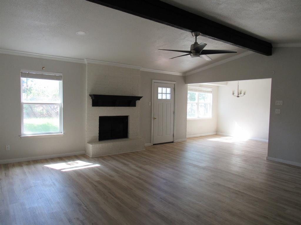 2104 Dan Rowe Street Waco, TX 76704 - Photo 3 of 14 an empty room with wooden floor fireplace and windows
