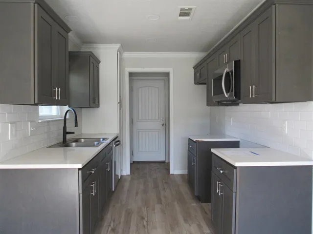 a kitchen that has a sink and a stove in it