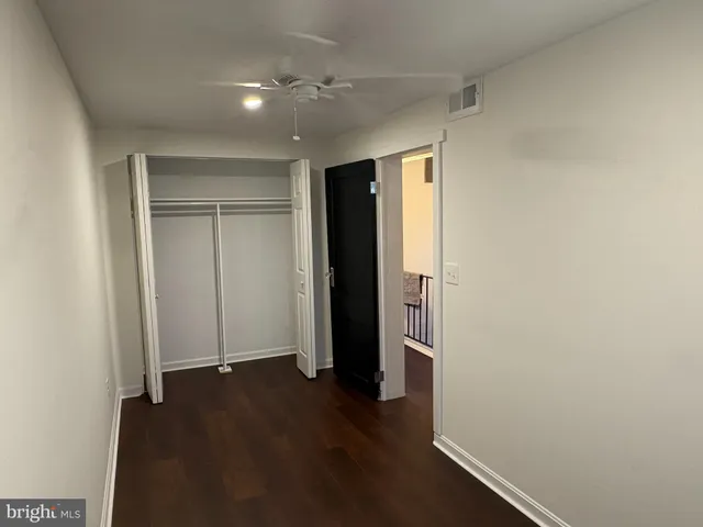 an empty room with wooden floor and closet