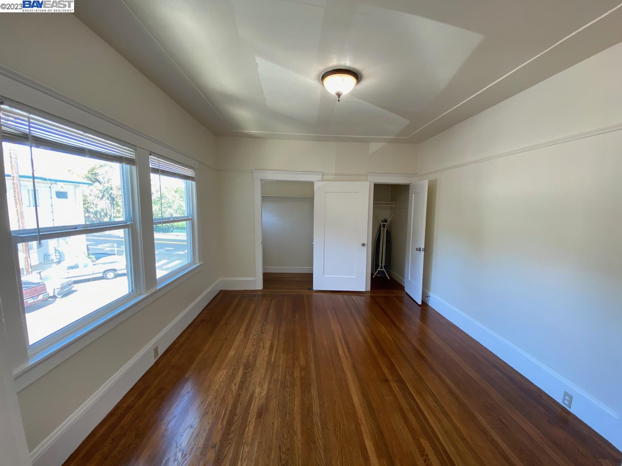 Ivy Hill Oakland, CA 94606 - Photo 11 of 19 a view of an empty room with wooden floor and a window