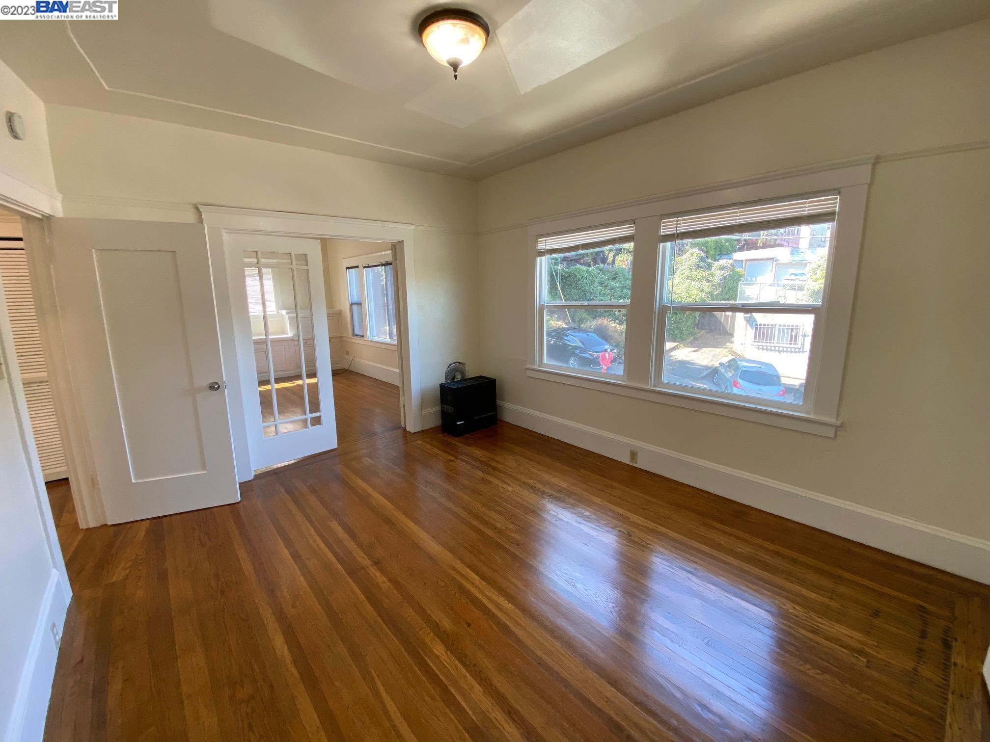 Ivy Hill Oakland, CA 94606 - Photo 12 of 19 an empty room with wooden floor and windows
