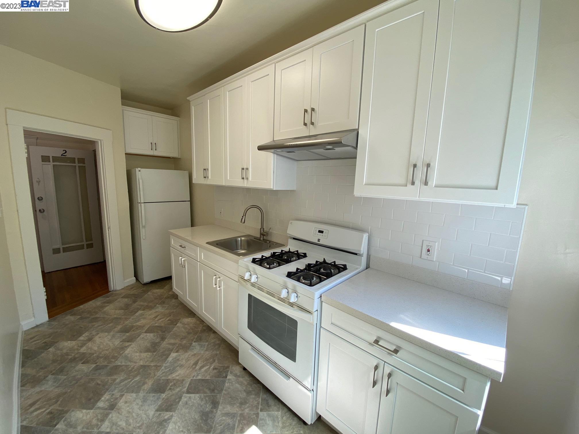 Ivy Hill Oakland, CA 94606 - Photo 6 of 19 a kitchen with white cabinets and white appliances