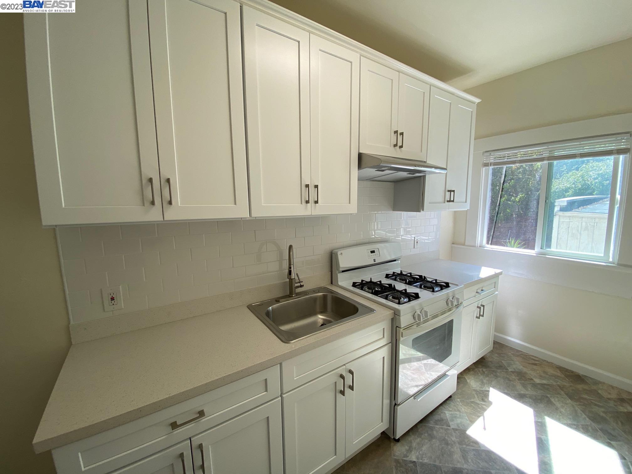 Ivy Hill Oakland, CA 94606 - Photo 7 of 19 a kitchen with white cabinets and white appliances
