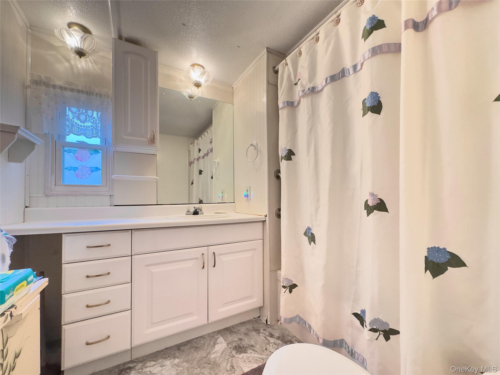1964 River Road, Unit 55 Calverton, NY 11933 - Photo 7 of 13 a bathroom with a double vanity sink mirror and shower