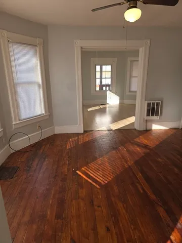wooden floor in an empty room with a window