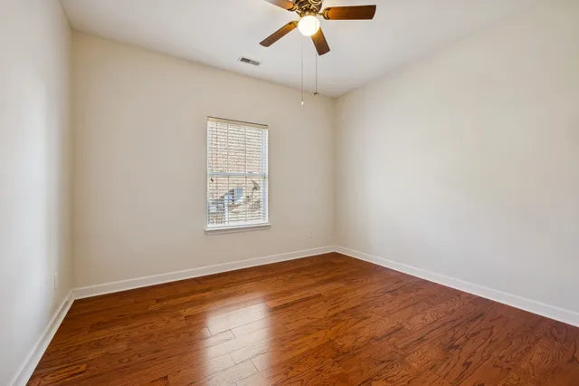 an empty room with a window and a ceiling fan
