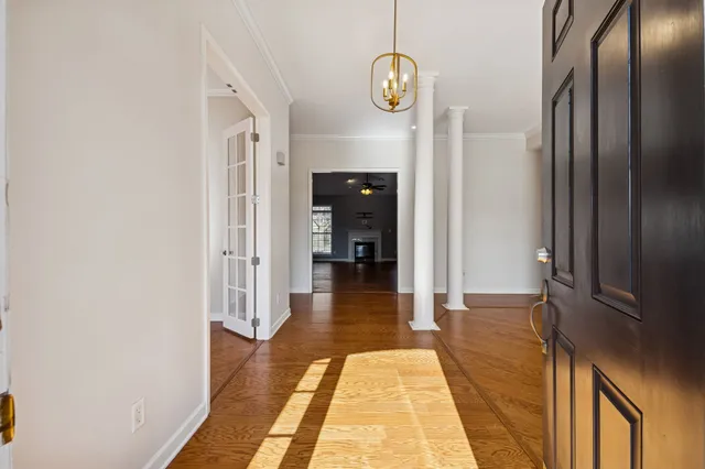 a view of a hallway with wooden floor and staircase