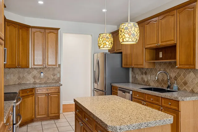 a kitchen with stainless steel appliances granite countertop a sink refrigerator and microwave