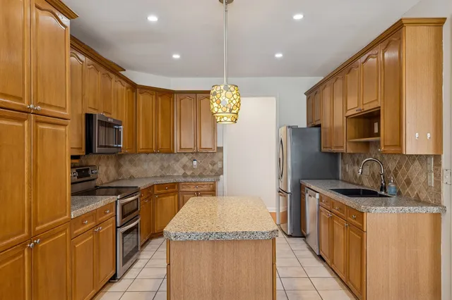 a kitchen with stainless steel appliances granite countertop a sink stove and refrigerator