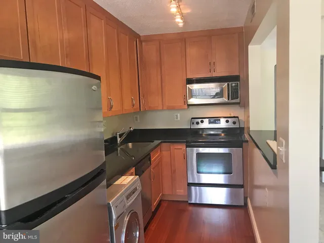 a kitchen with granite countertop a stove and a microwave