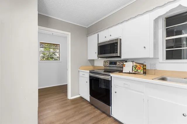 a kitchen with stainless steel appliances granite countertop a stove a sink and a microwave