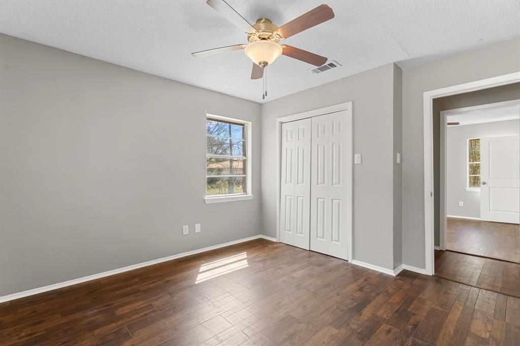 685 Sides Circle Canton, TX 75103 - Photo 20 of 32 an empty room with wooden floor chandelier fan and windows
